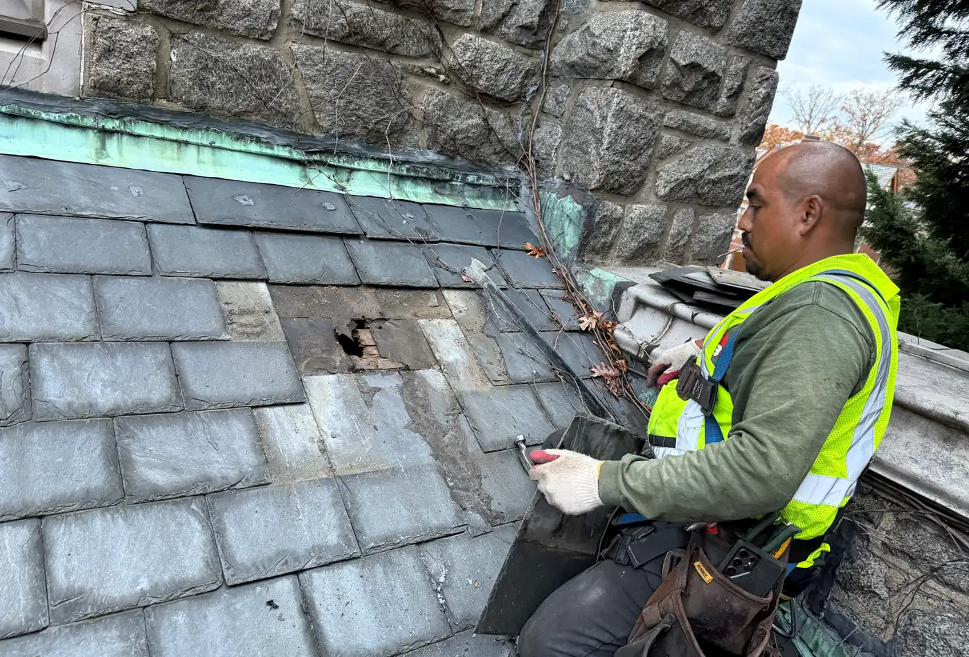 Worker replacing slate on a church roof