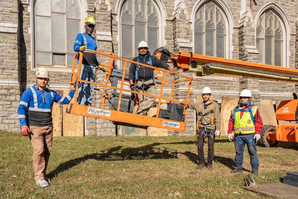 The Usource crew and their aerial lift beside the church