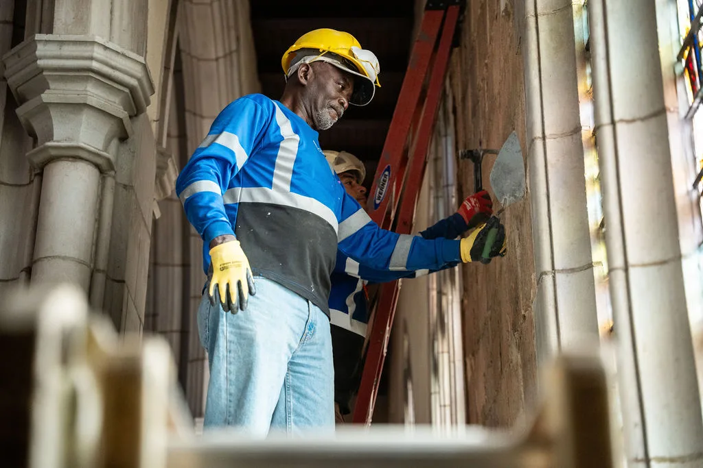 Usource mason working on the stonework inside the sanctuary