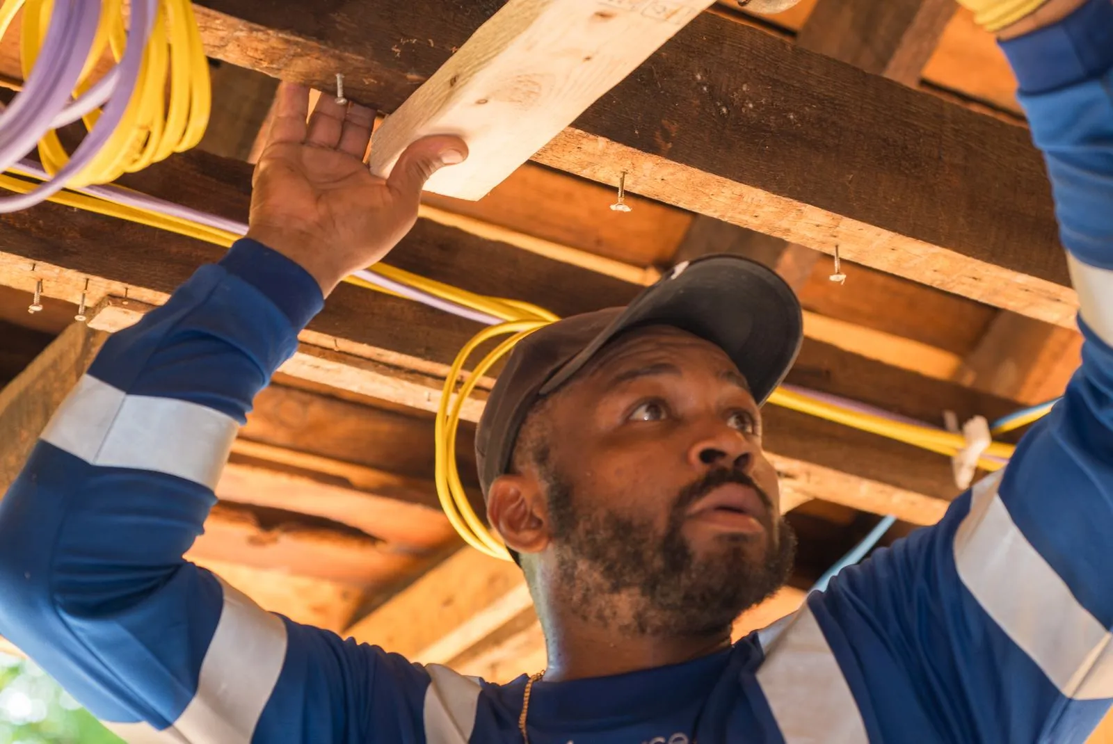 Usource carpenter working under open floor joists