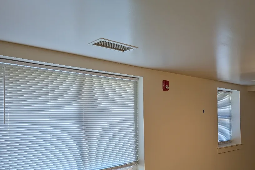 Bedroom with new flooring and window blinds