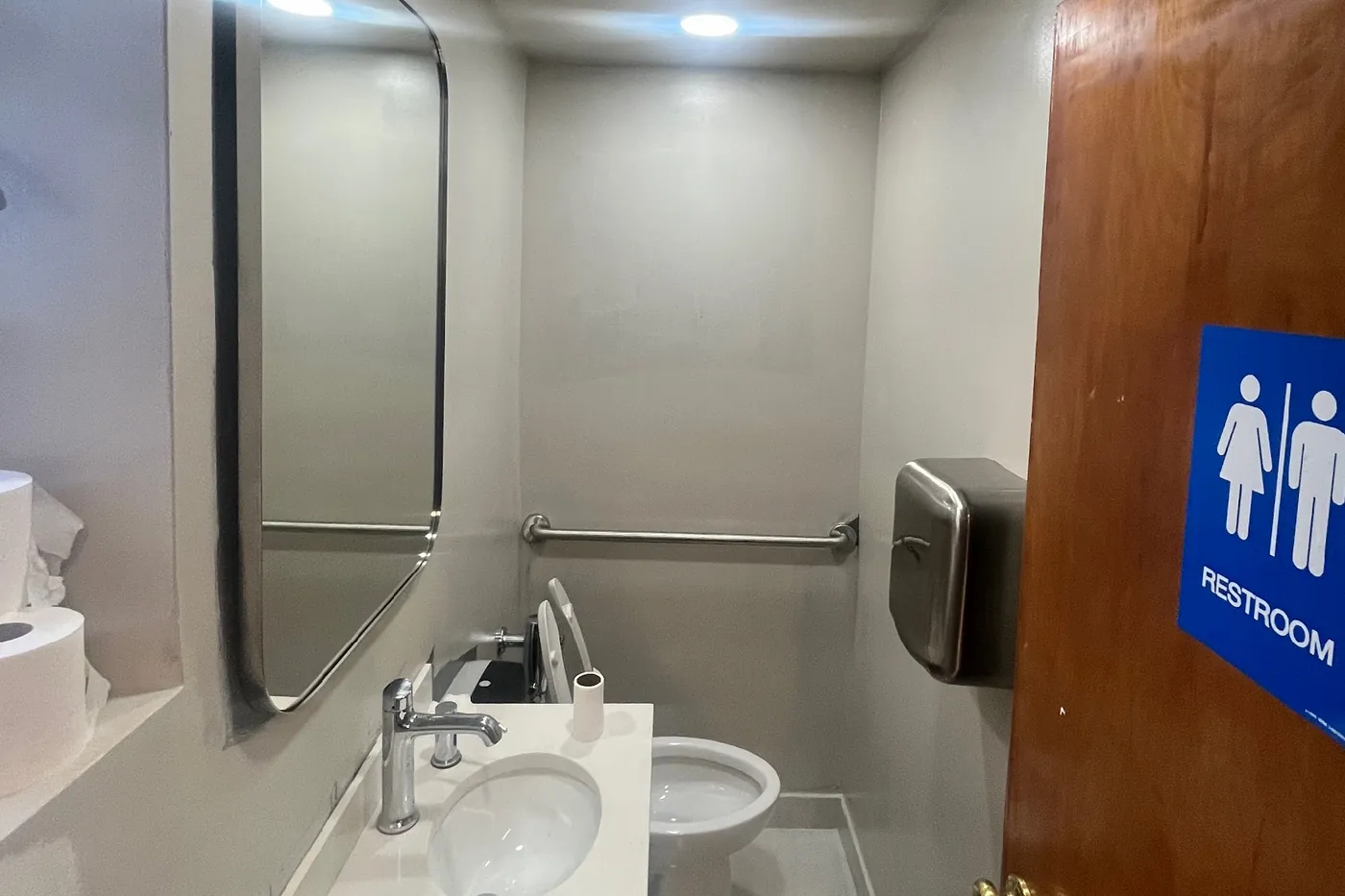 Modernized restroom at Trinity Episcopal Church with grab bars and unisex signage
